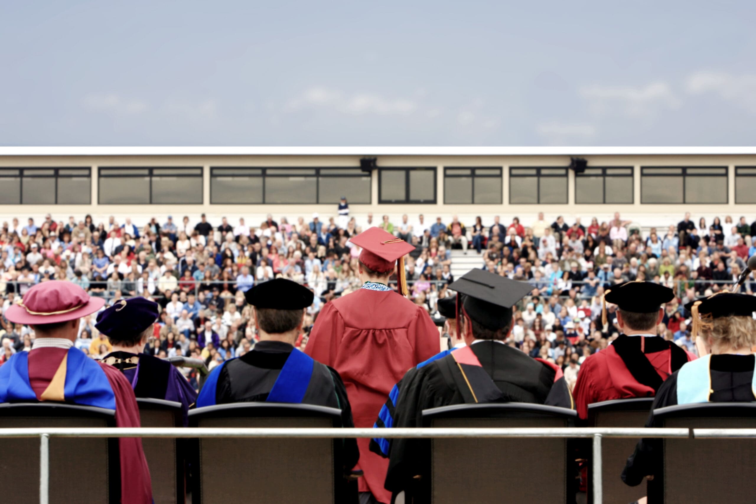 Rear view of valedictorian giving a speech during college graduation ceremony.